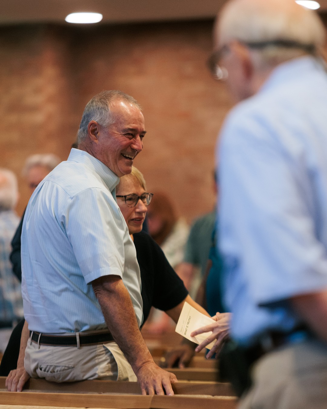 Members sharing a laugh in the pews